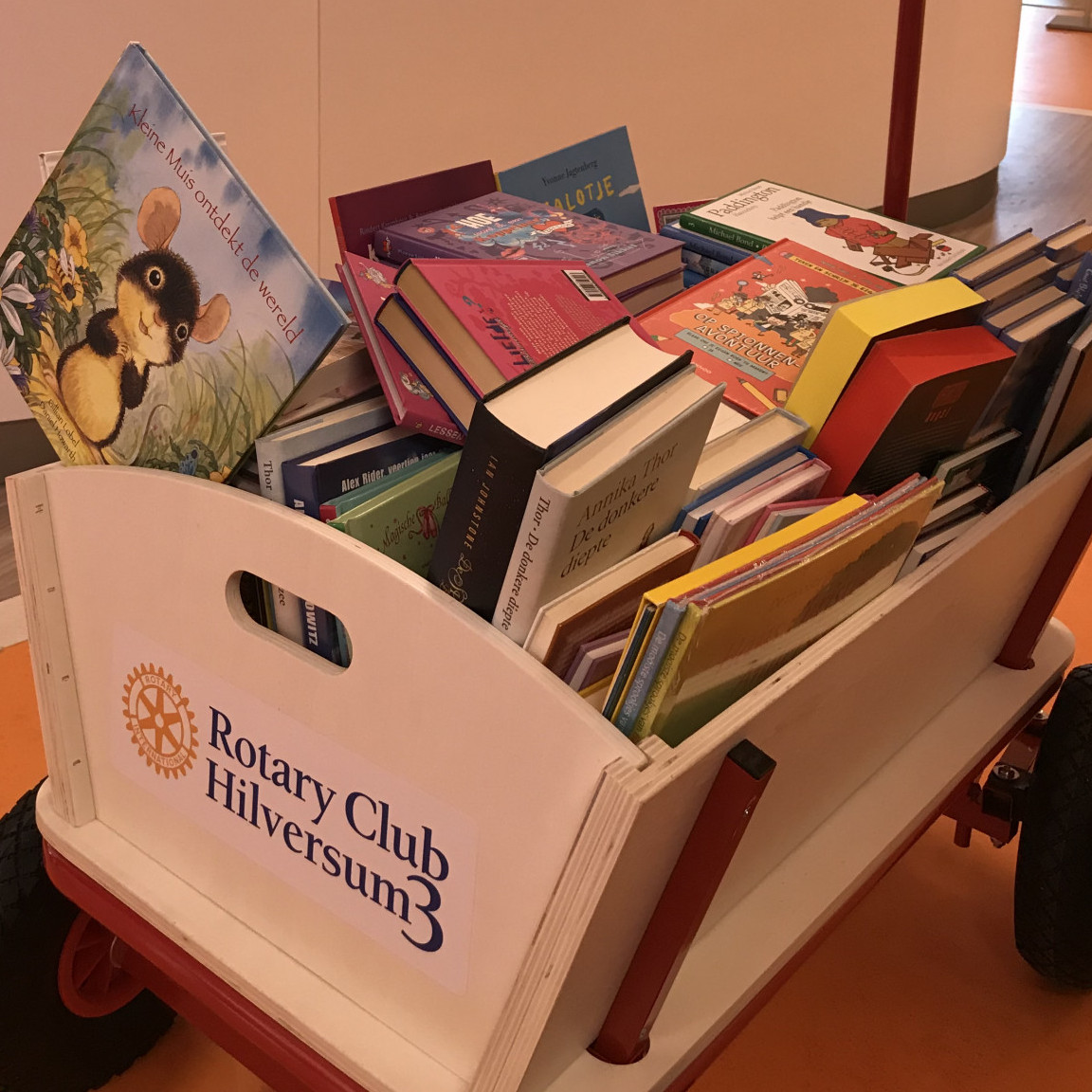 Rotaryclub Hilversum 3 schenkt een bolderkar vol kinderboeken
